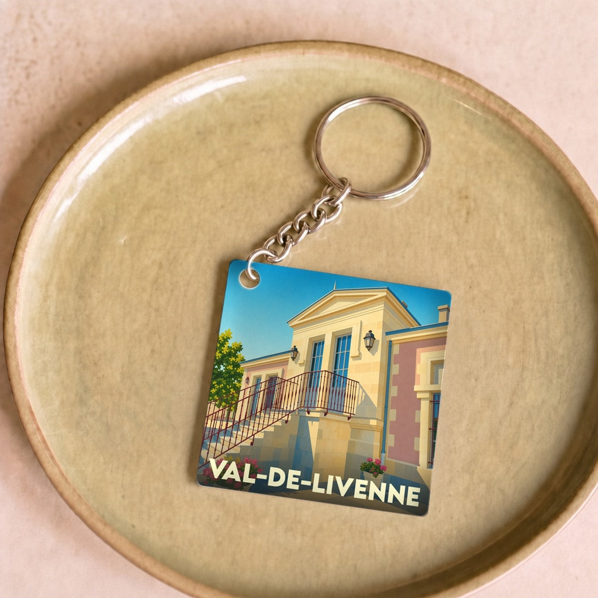 Porte-clés souvenir de la ville de Val-de-Livenne avec une illustration stylisée.