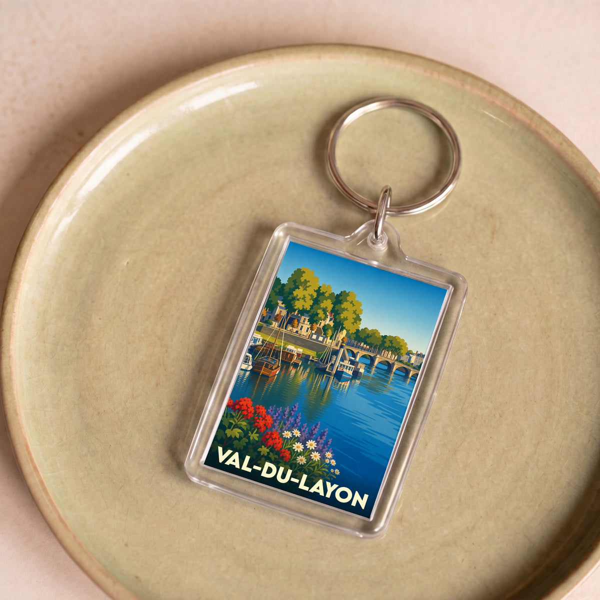 Porte-clés souvenir de la ville de Val-du-Layon avec une illustration stylisée d'un paysage fluvial.