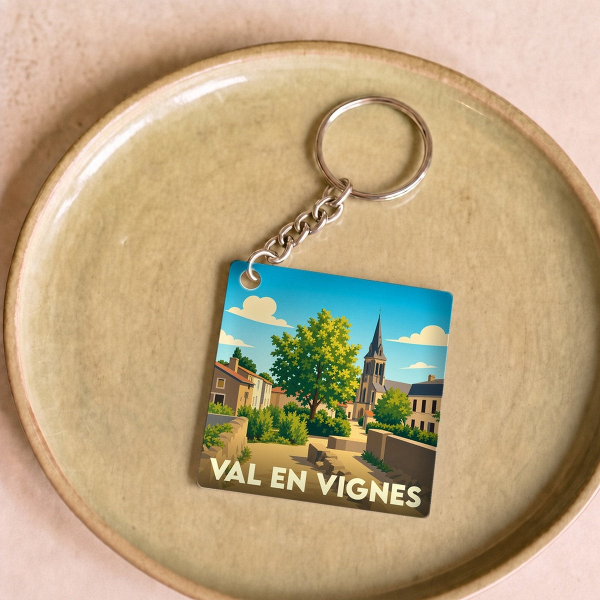 Porte-clés souvenir de la ville de Val en Vignes avec une illustration stylisée.