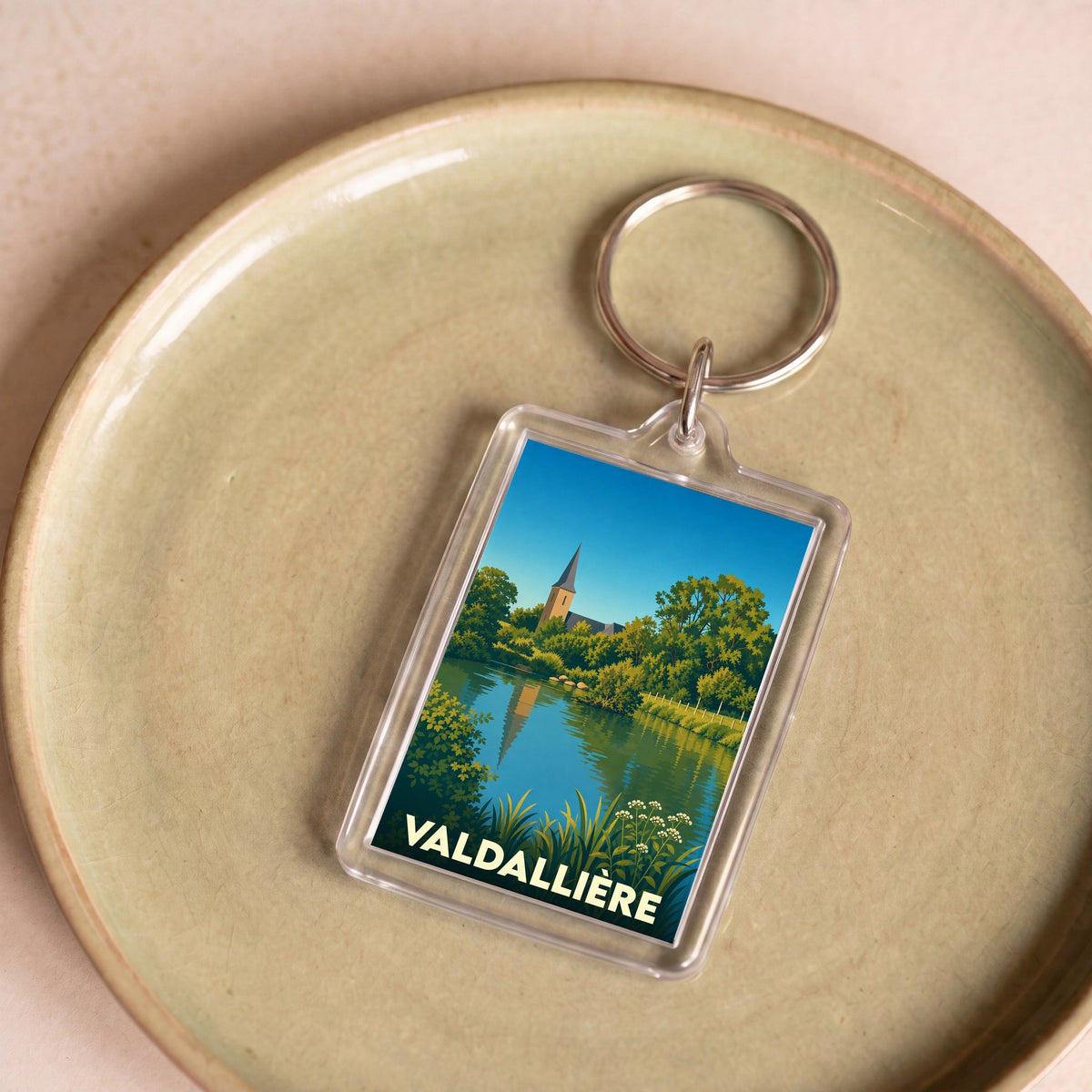Porte-clés souvenir de la ville de Valdallière avec une illustration stylisée de son paysage.