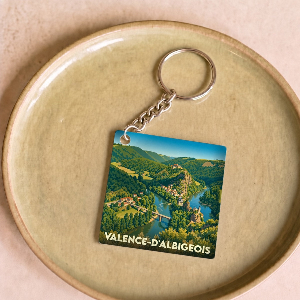 Porte-clés souvenir de la ville de Valence-d'Albigeois avec une illustration stylisée de son paysage.