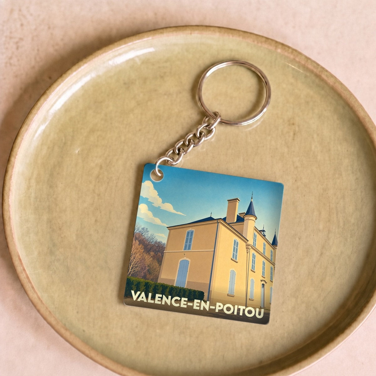 Porte-clés souvenir de la ville de Valence-en-Poitou avec une illustration stylisée.