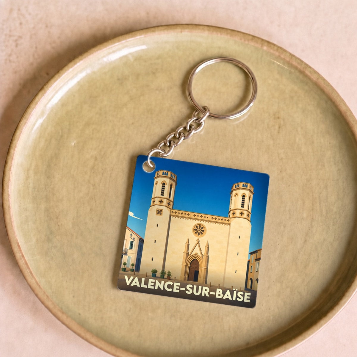 Porte-clés souvenir de la ville de Valence-sur-Baïse avec une illustration stylisée de son église.