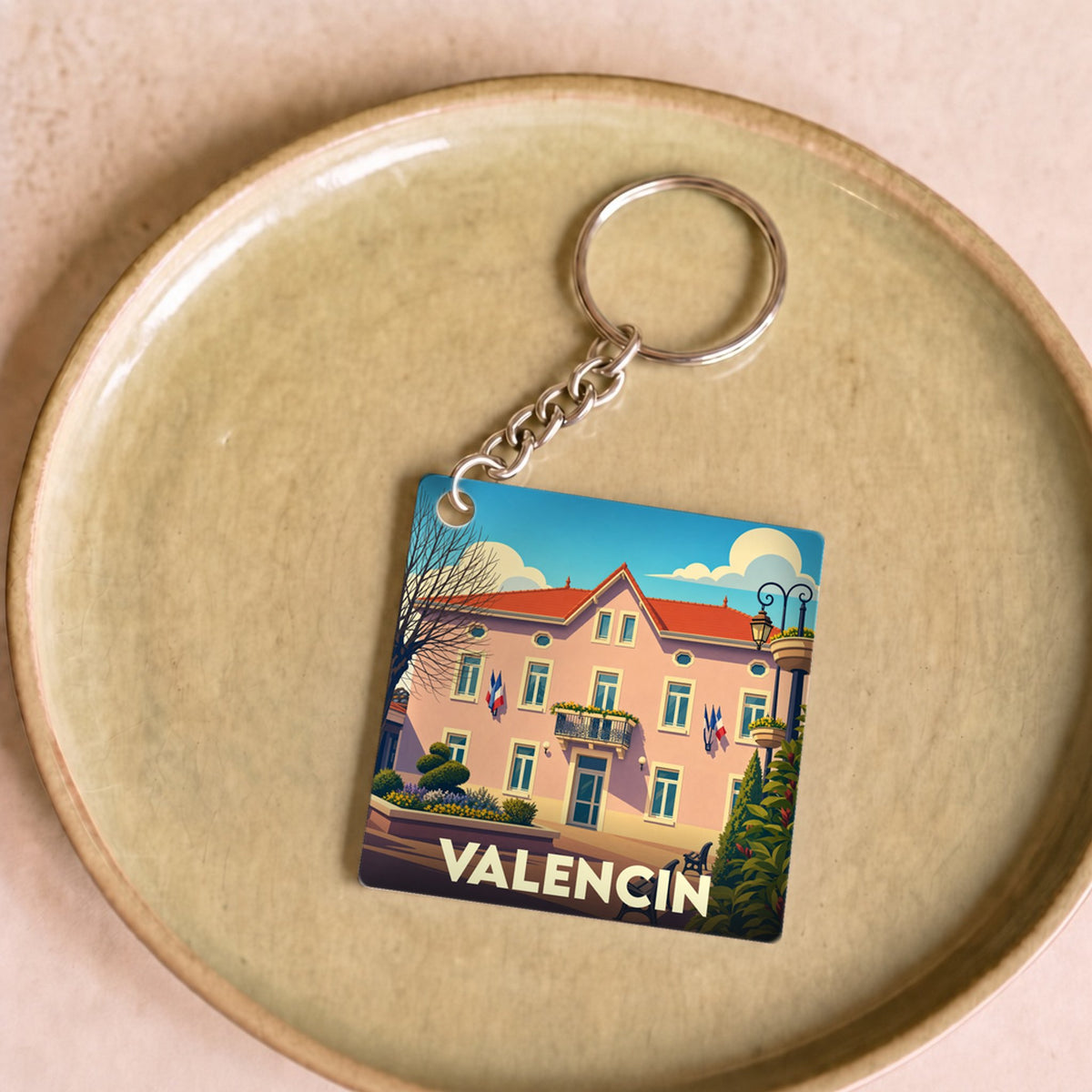 Porte-clés souvenir de la ville de Valencin avec une illustration stylisée de sa mairie.