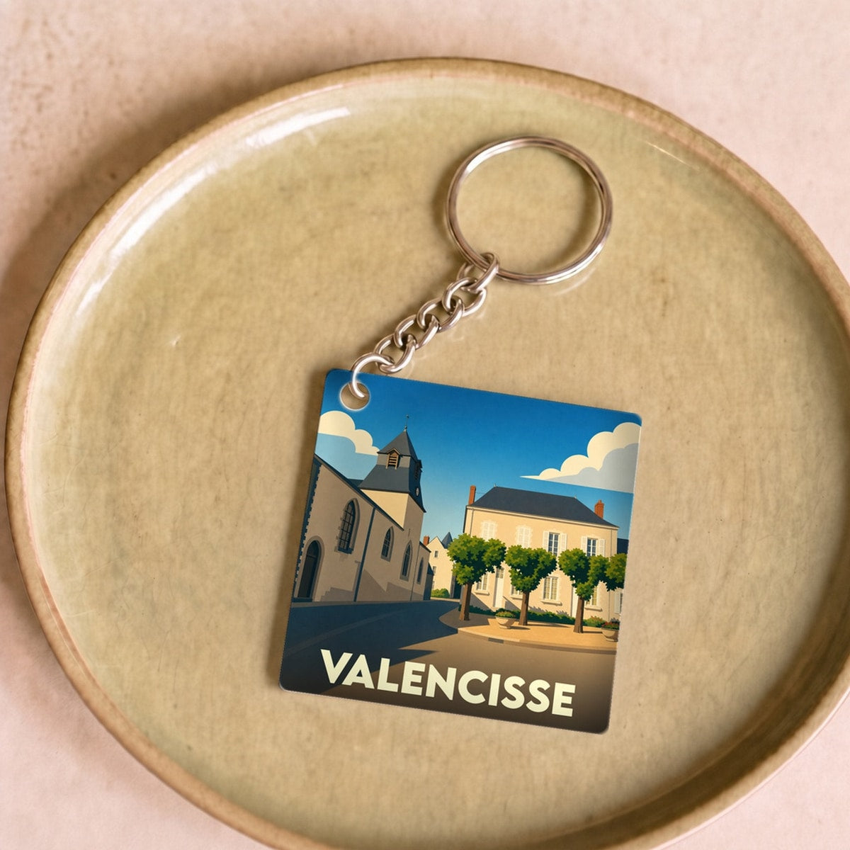 Porte-clés souvenir de la ville de Valencisse avec une illustration stylisée.