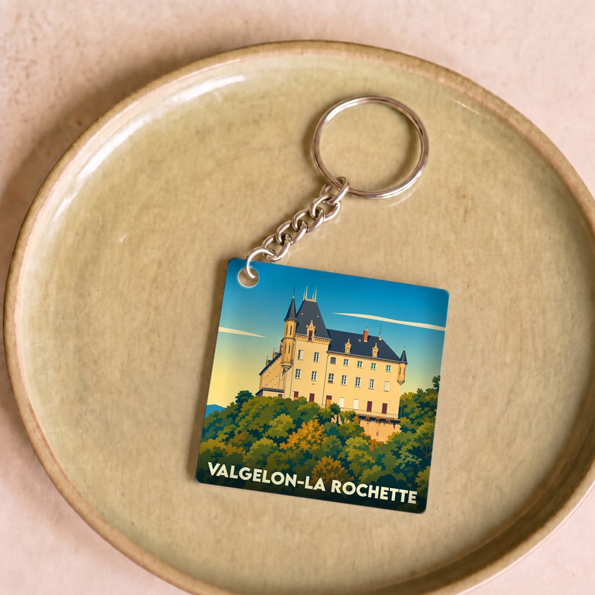 Porte-clés souvenir de Valgelon-La Rochette avec une illustration stylisée du château sur sa colline boisée.