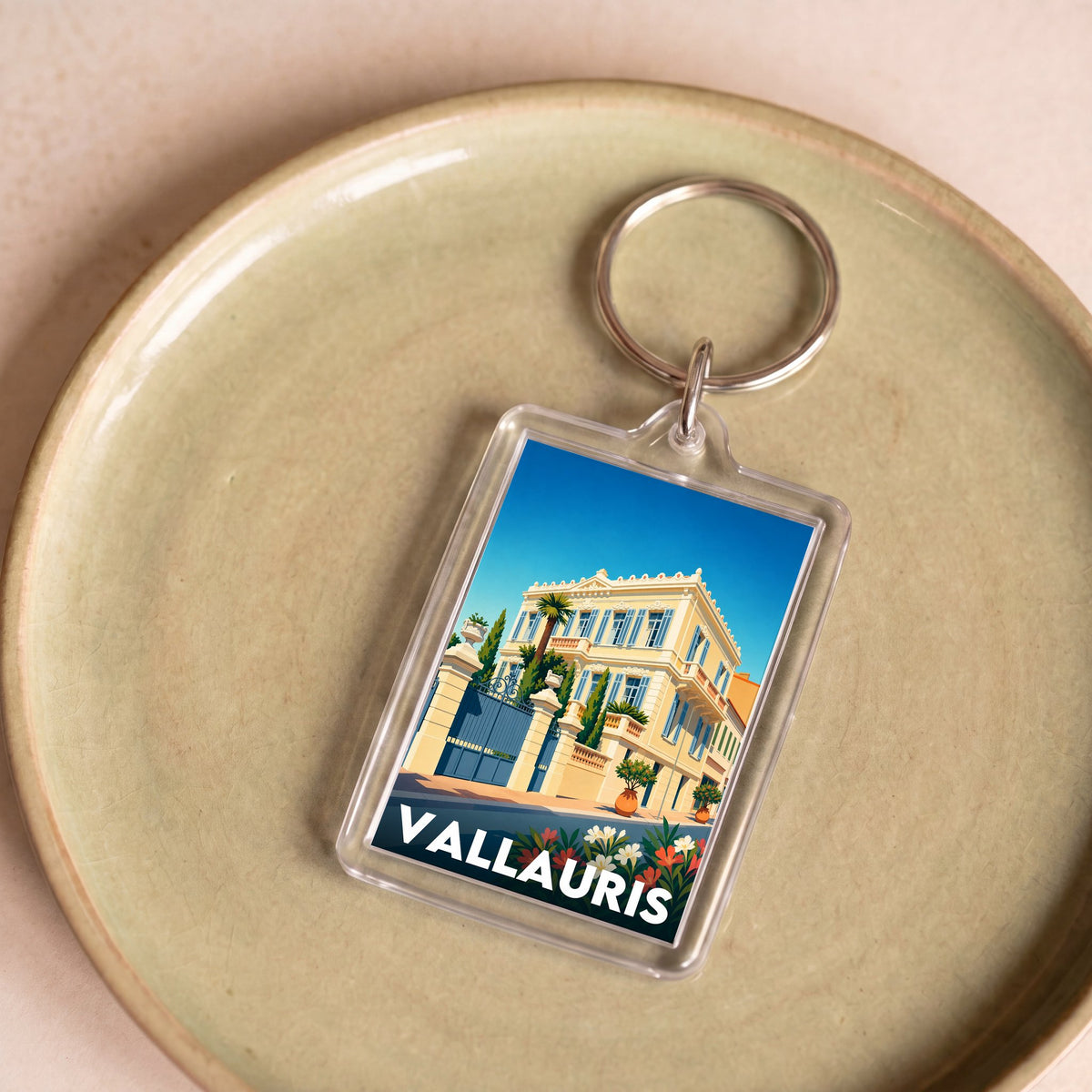 Porte-clés souvenir de la ville de Vallauris avec une illustration stylisée d'une villa.