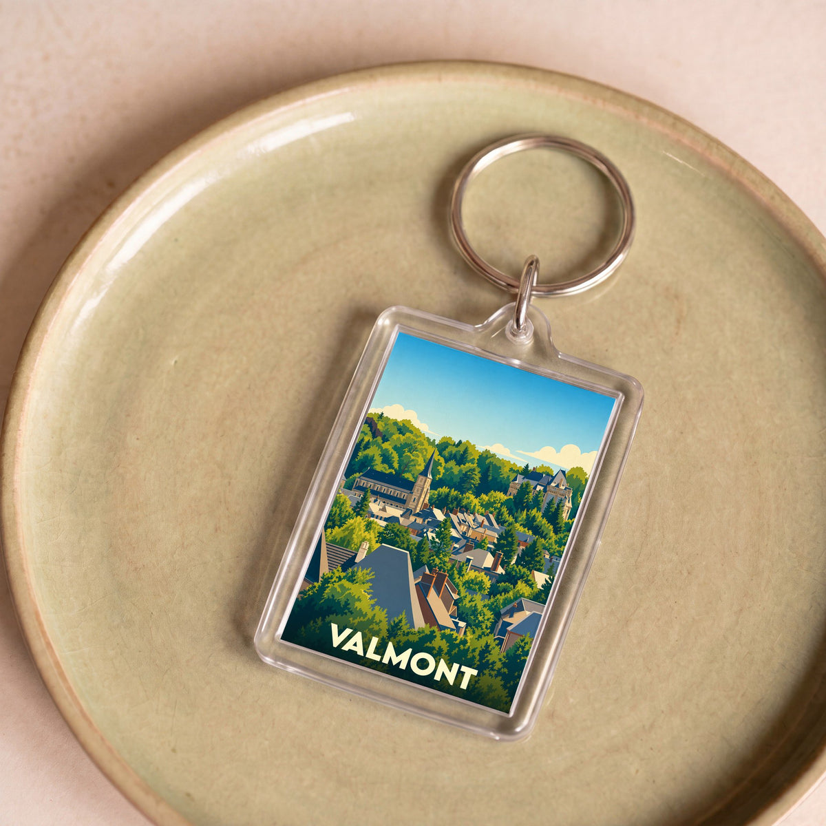 Porte-clés souvenir de la ville de Valmont avec une illustration stylisée.