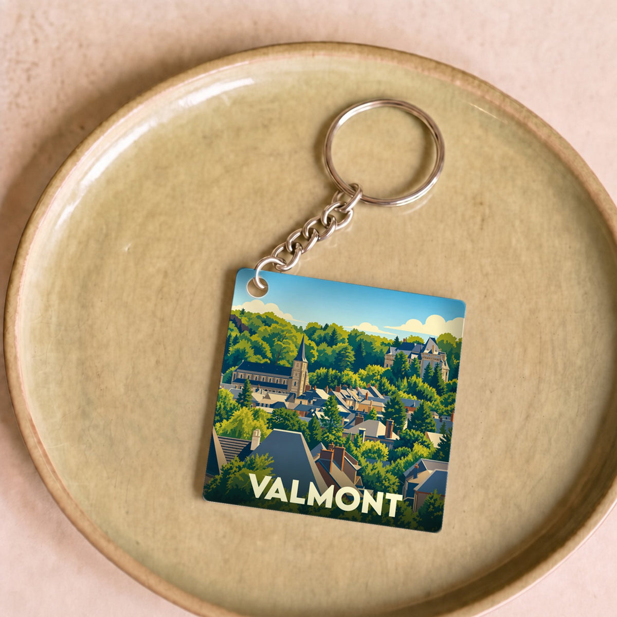 Porte-clés souvenir de la ville de Valmont avec une illustration stylisée.
