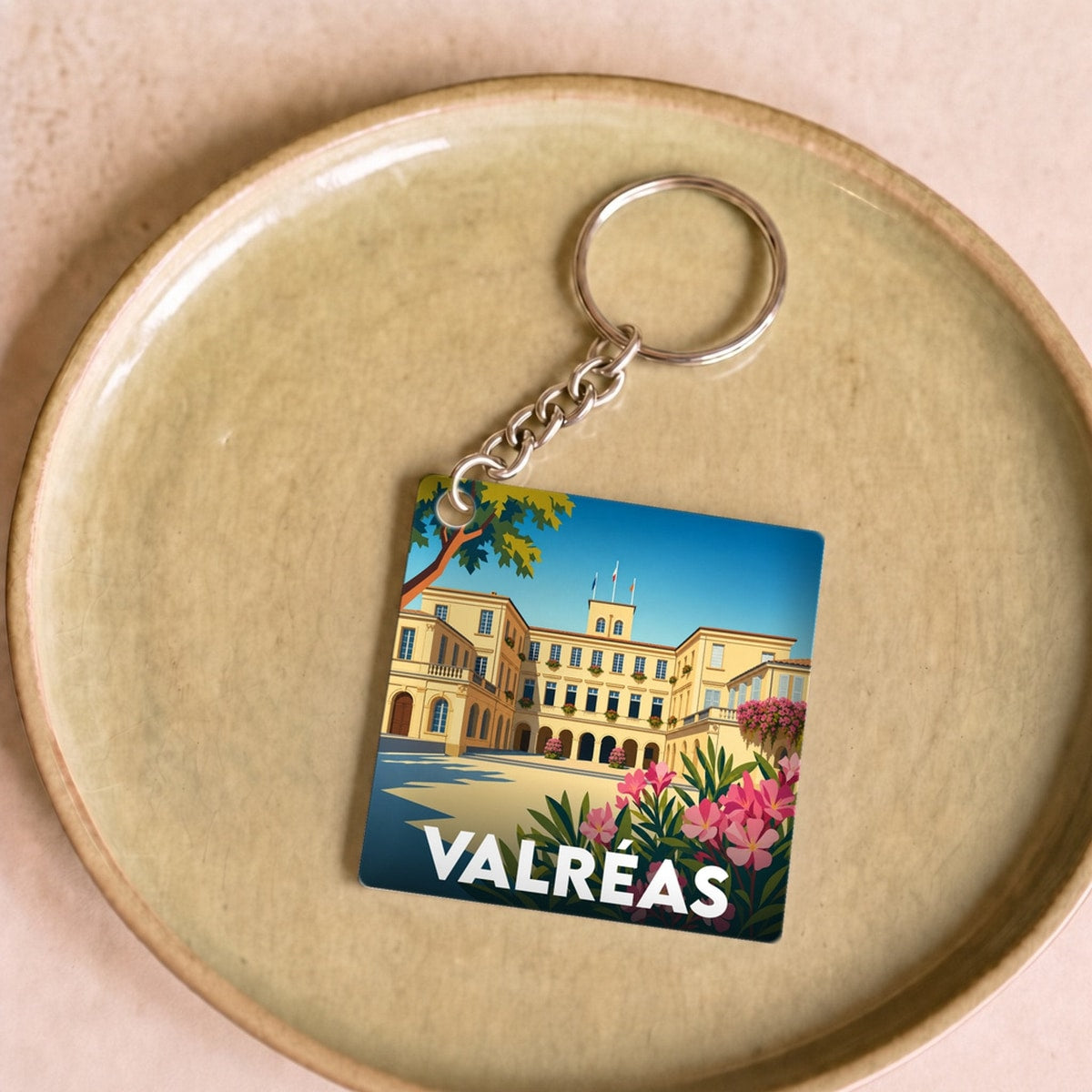 Porte-clés souvenir de la ville de Valréas avec une illustration colorée du château de Simiane.