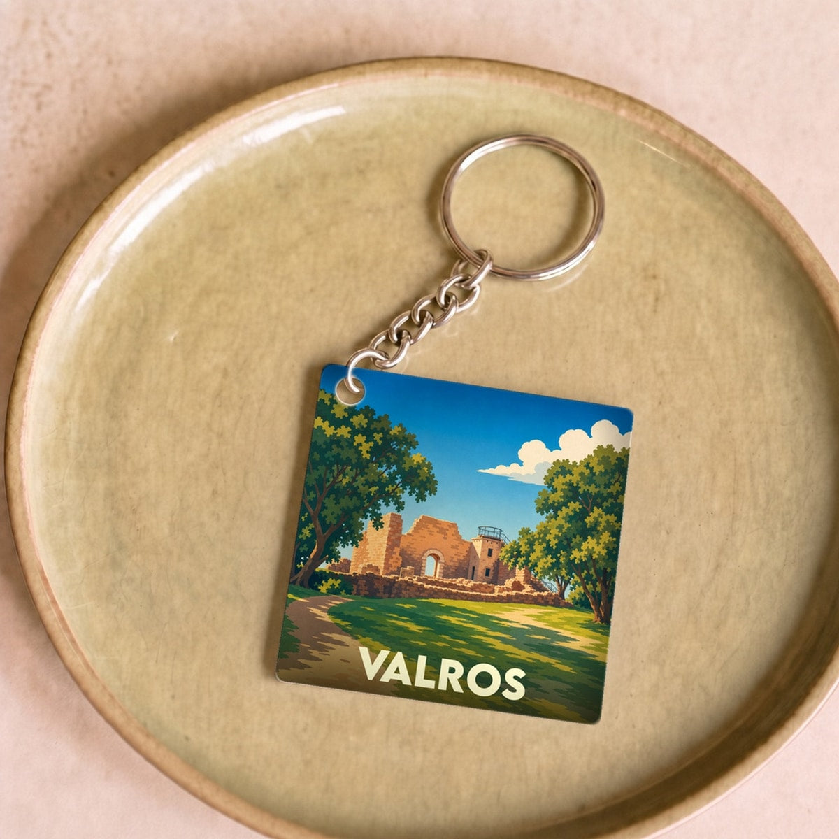 Porte-clés souvenir de la ville de Valros avec une illustration stylisée de ses vestiges historiques.