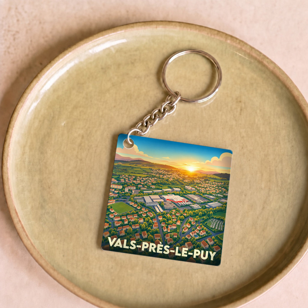 Porte-clés souvenir de la ville de Vals-près-le-Puy avec une illustration stylisée.