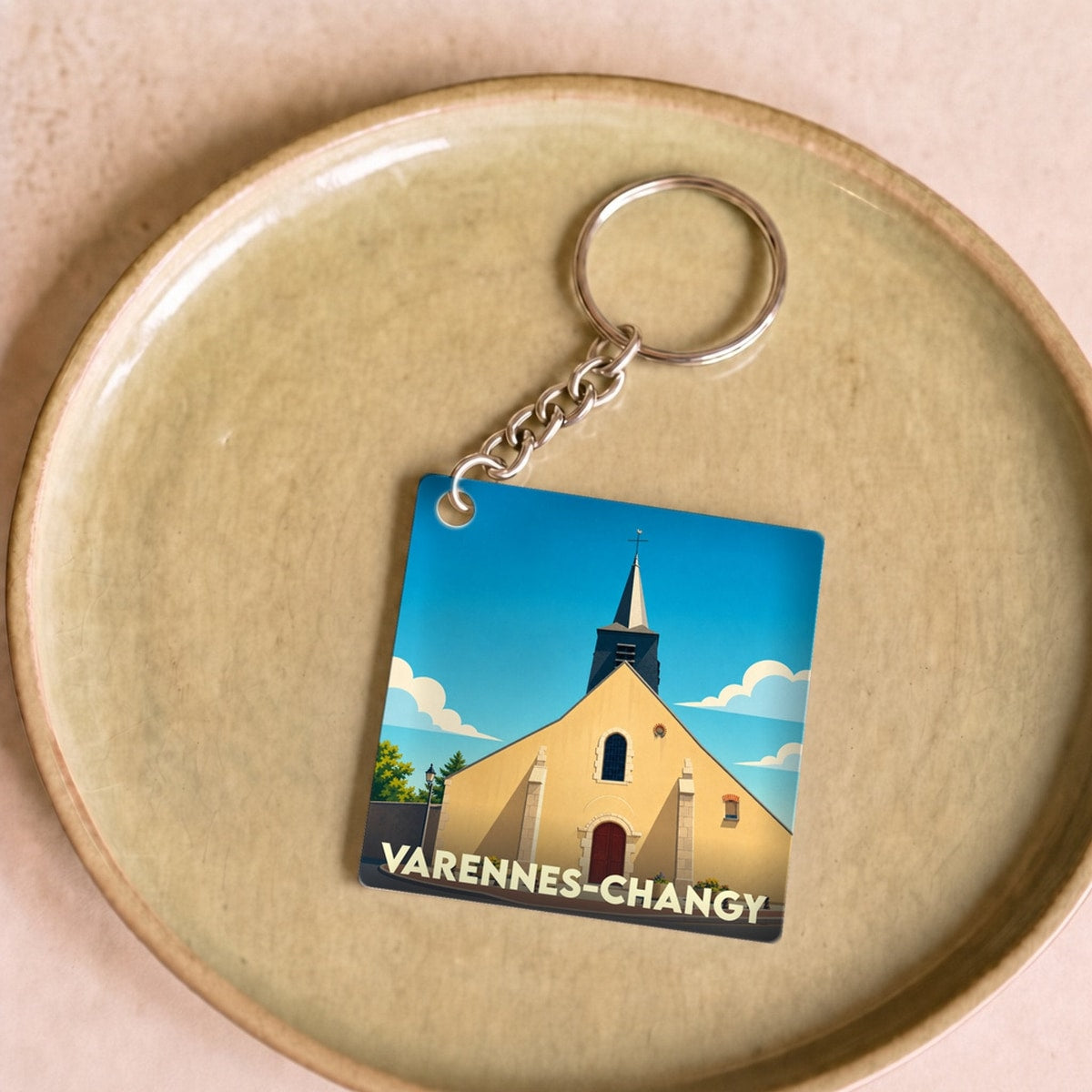 Porte-clés souvenir de la ville de Varennes-Changy avec une illustration stylisée de son église.