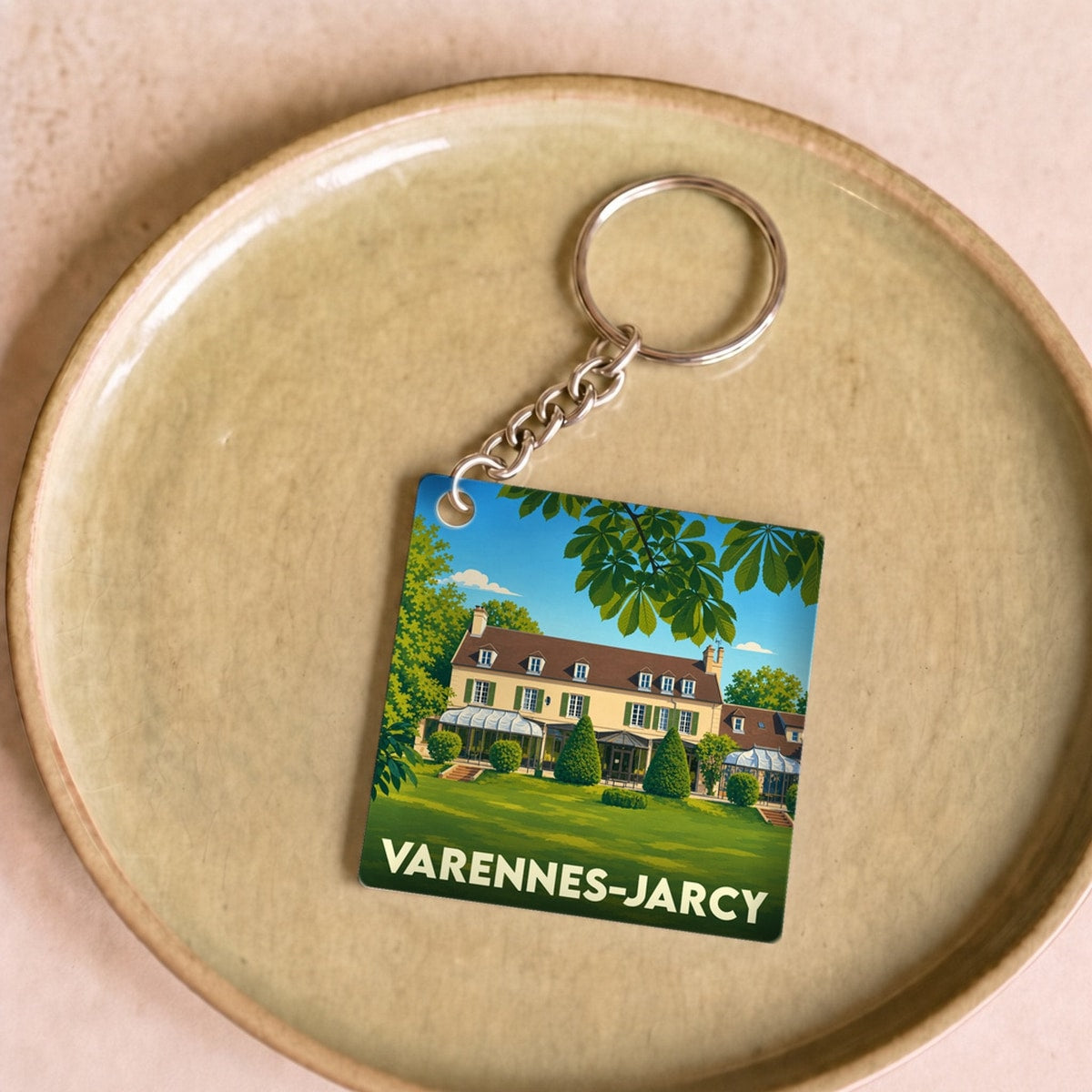 Porte-clés souvenir de la ville de Varennes-Jarcy avec une illustration stylisée d'une grande demeure.