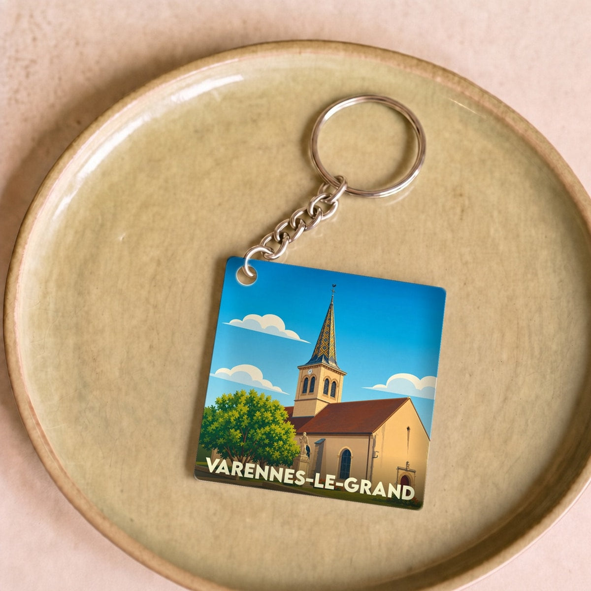 Porte-clés souvenir de la ville de Varennes-le-Grand avec une illustration stylisée.