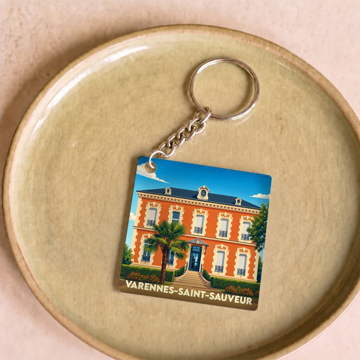 Porte-clés souvenir de la ville de Varennes-Saint-Sauveur avec une illustration stylisée d'un bâtiment remarquable.