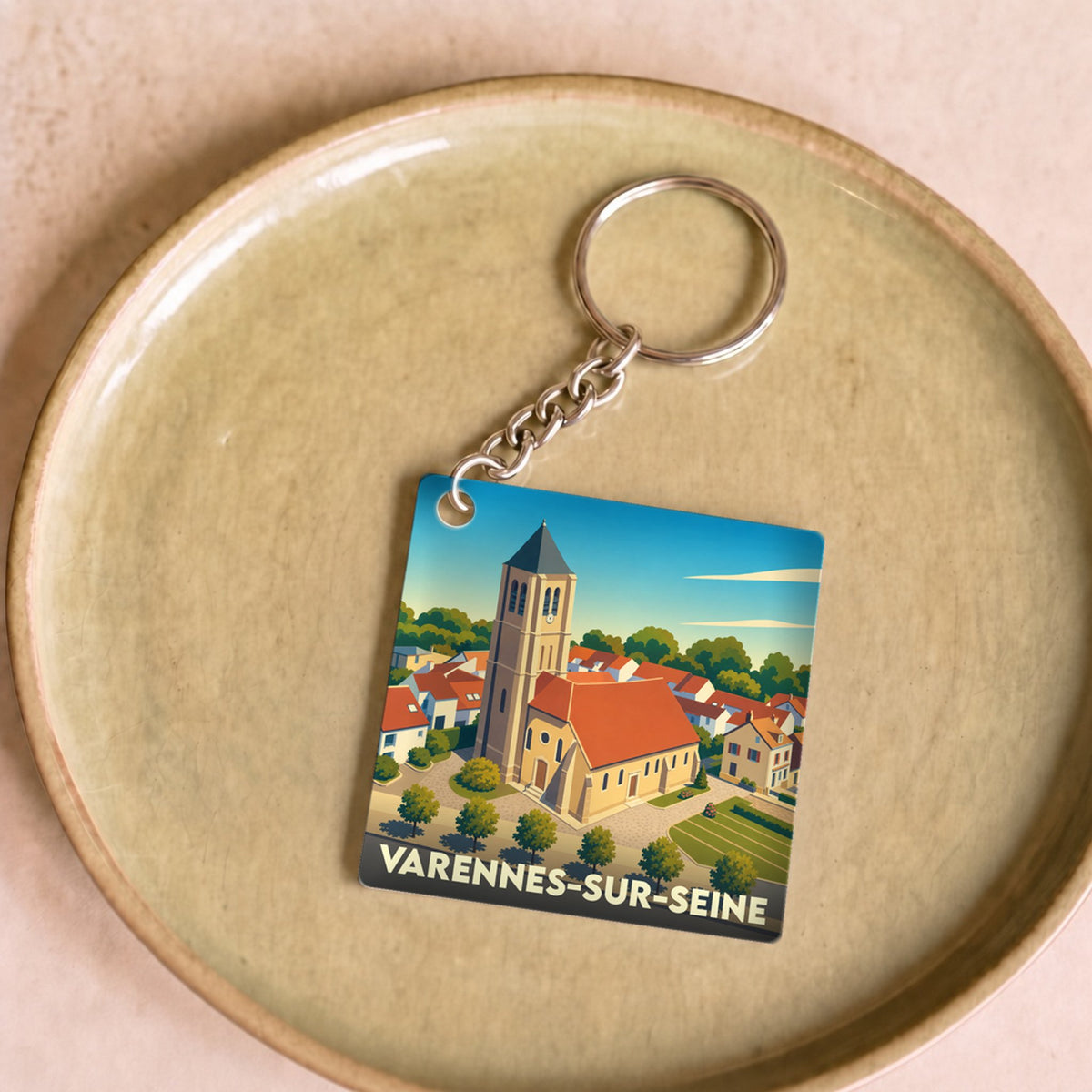Porte-clés souvenir de la ville de Varennes-sur-Seine avec une illustration stylisée de son église.