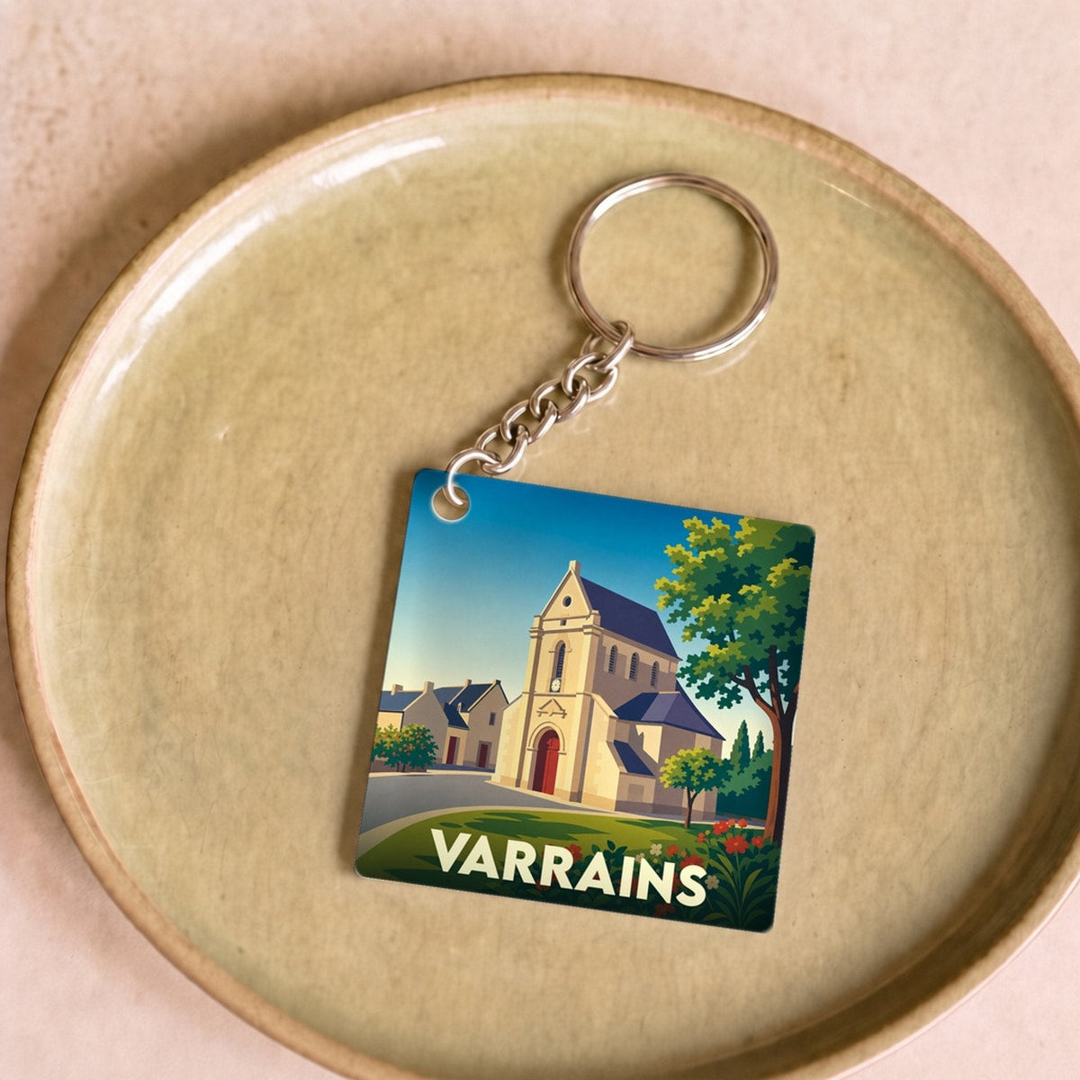 Porte-clés souvenir de la ville de Varrains avec une illustration stylisée de son église.