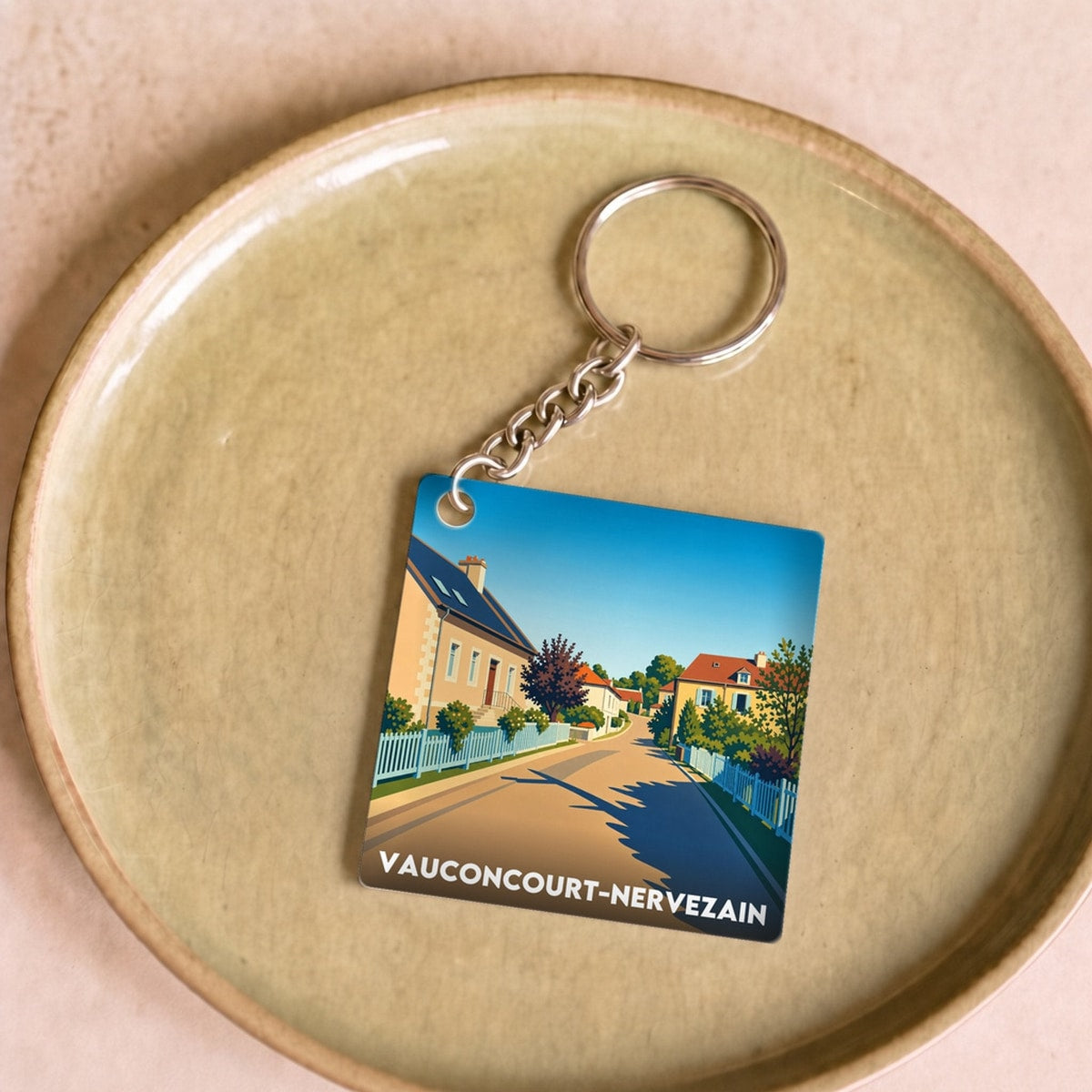 Porte-clés souvenir de la ville de Vauconcourt-Nervezain avec une illustration stylisée.