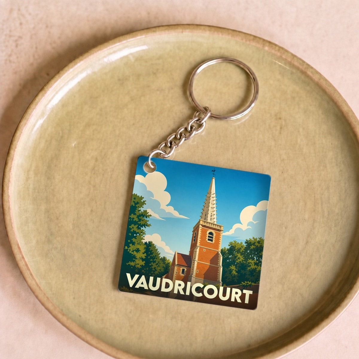 Porte-clés souvenir de la ville de Vaudricourt avec une illustration stylisée de son église.