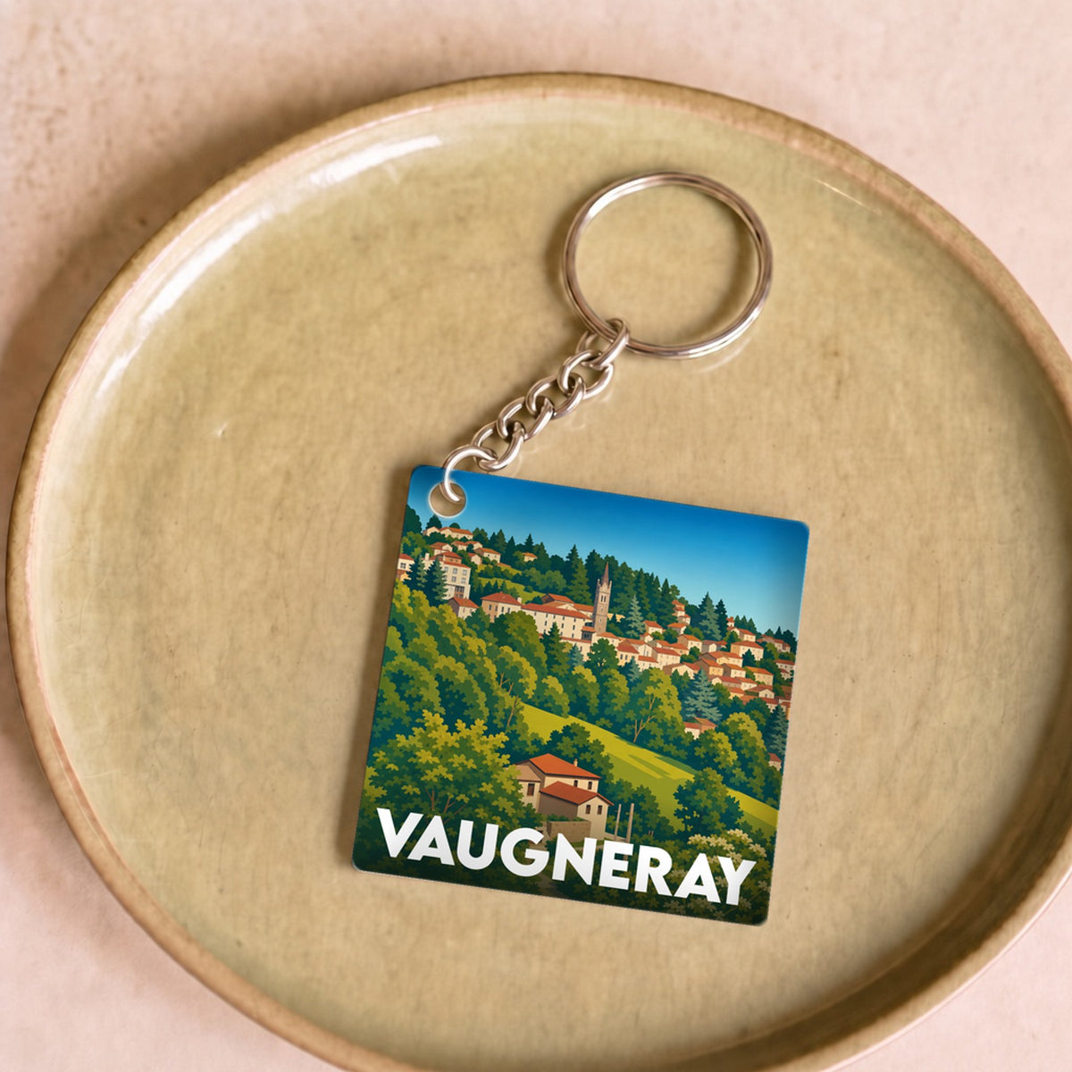 Porte-clés souvenir de la ville de Vaugneray avec une illustration stylisée.
