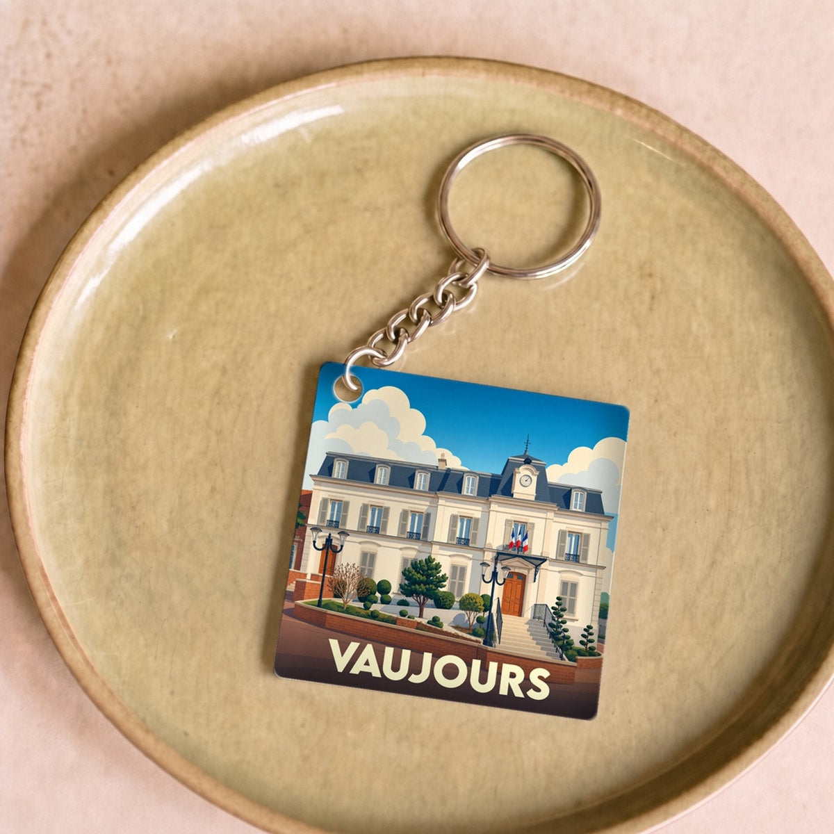 Porte-clés souvenir de la ville de Vaujours avec une illustration stylisée de son hôtel de ville.