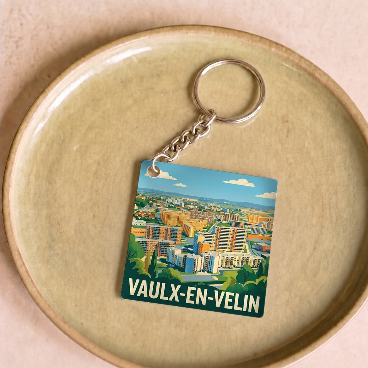 Porte-clés souvenir de la ville de Vaulx-en-Velin avec une illustration stylisée.