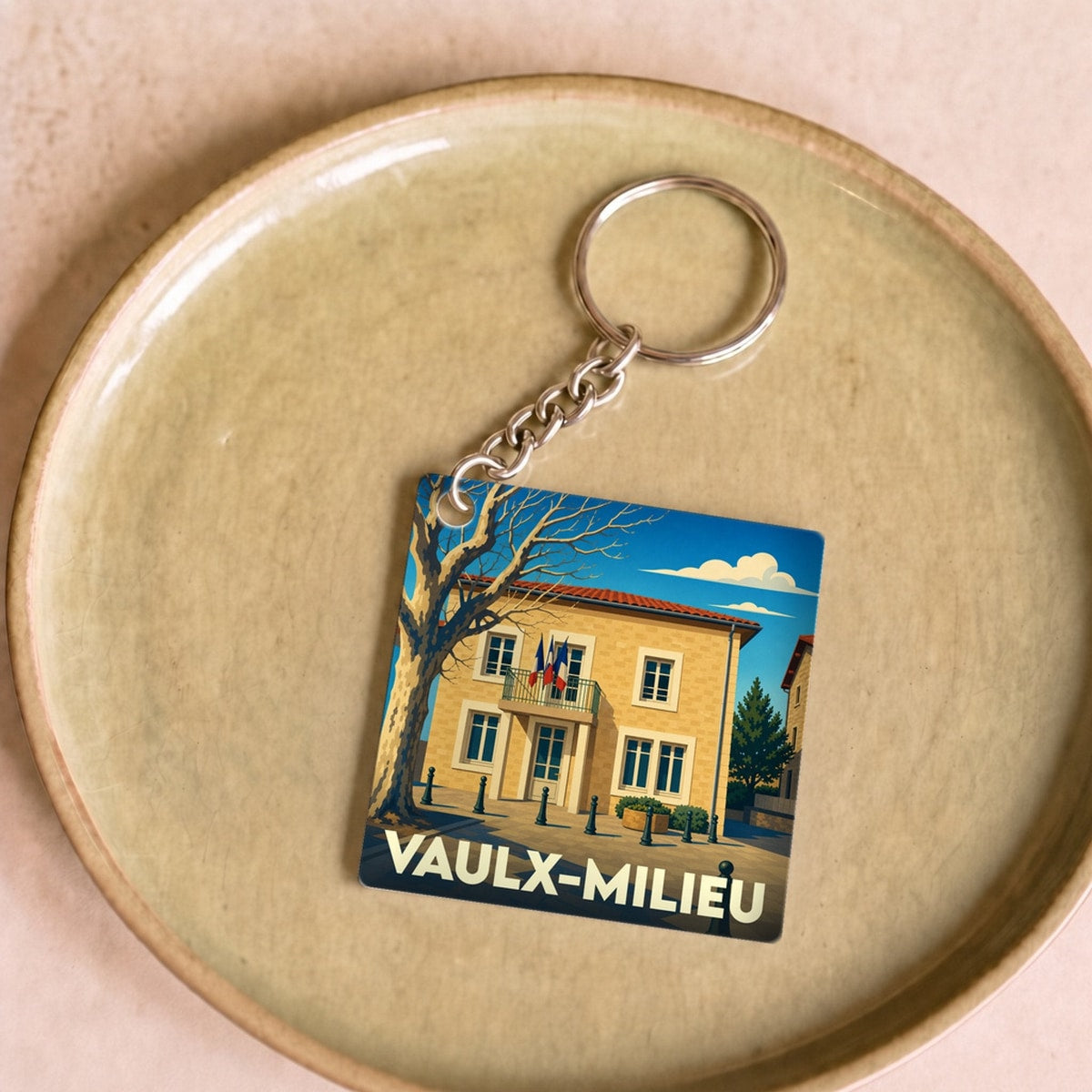 Porte-clés souvenir de la ville de Vaulx-Milieu avec une illustration stylisée de sa mairie.