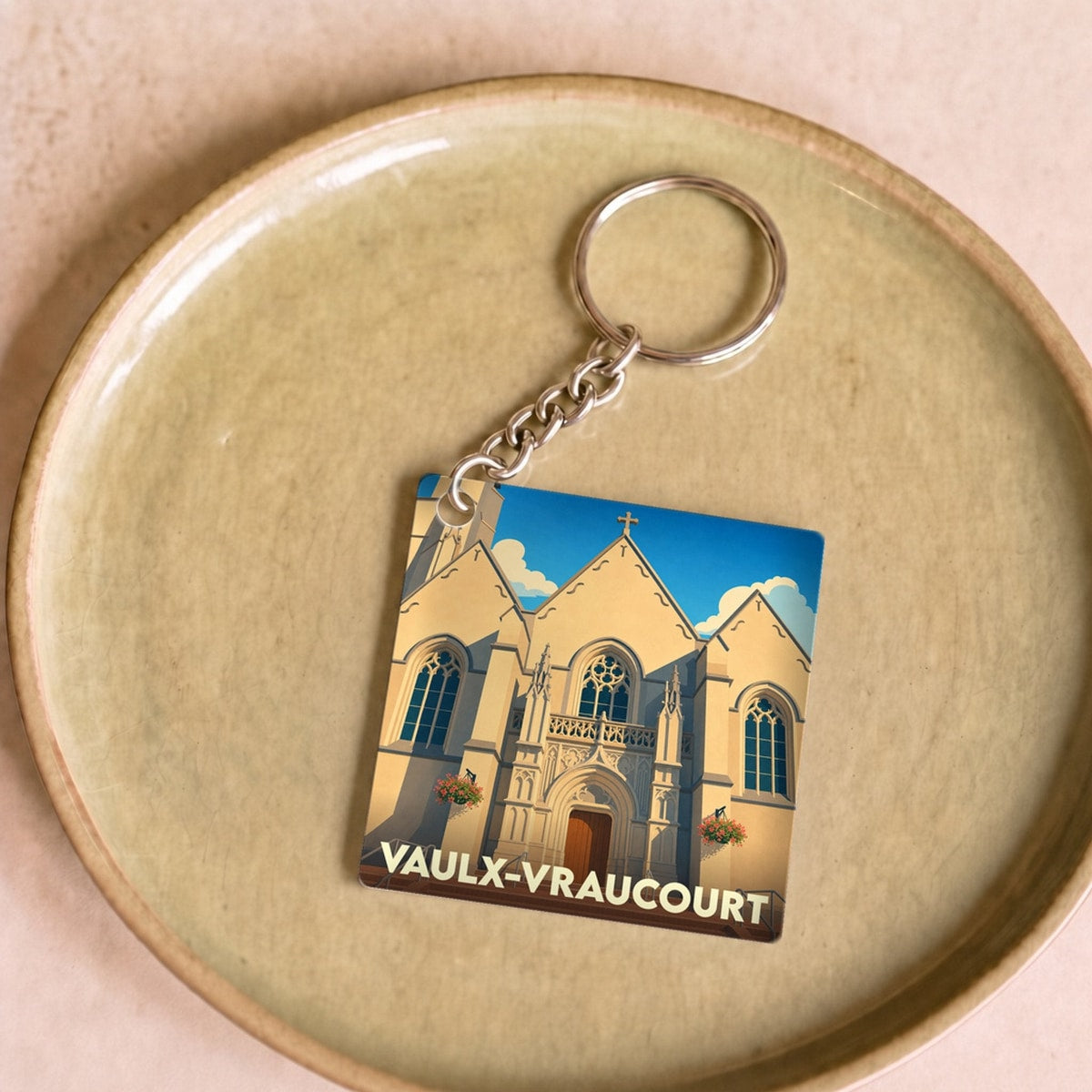 Porte-clés souvenir de la ville de Vaulx-Vraucourt avec une illustration stylisée de son église.