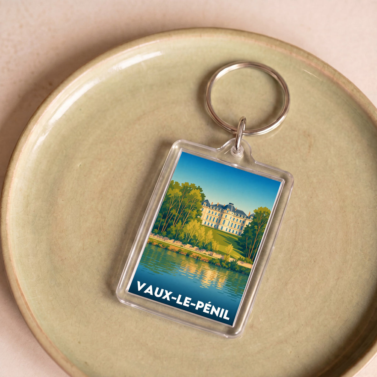 Porte-clés souvenir de la ville de Vaux-le-Pénil avec une illustration stylisée.