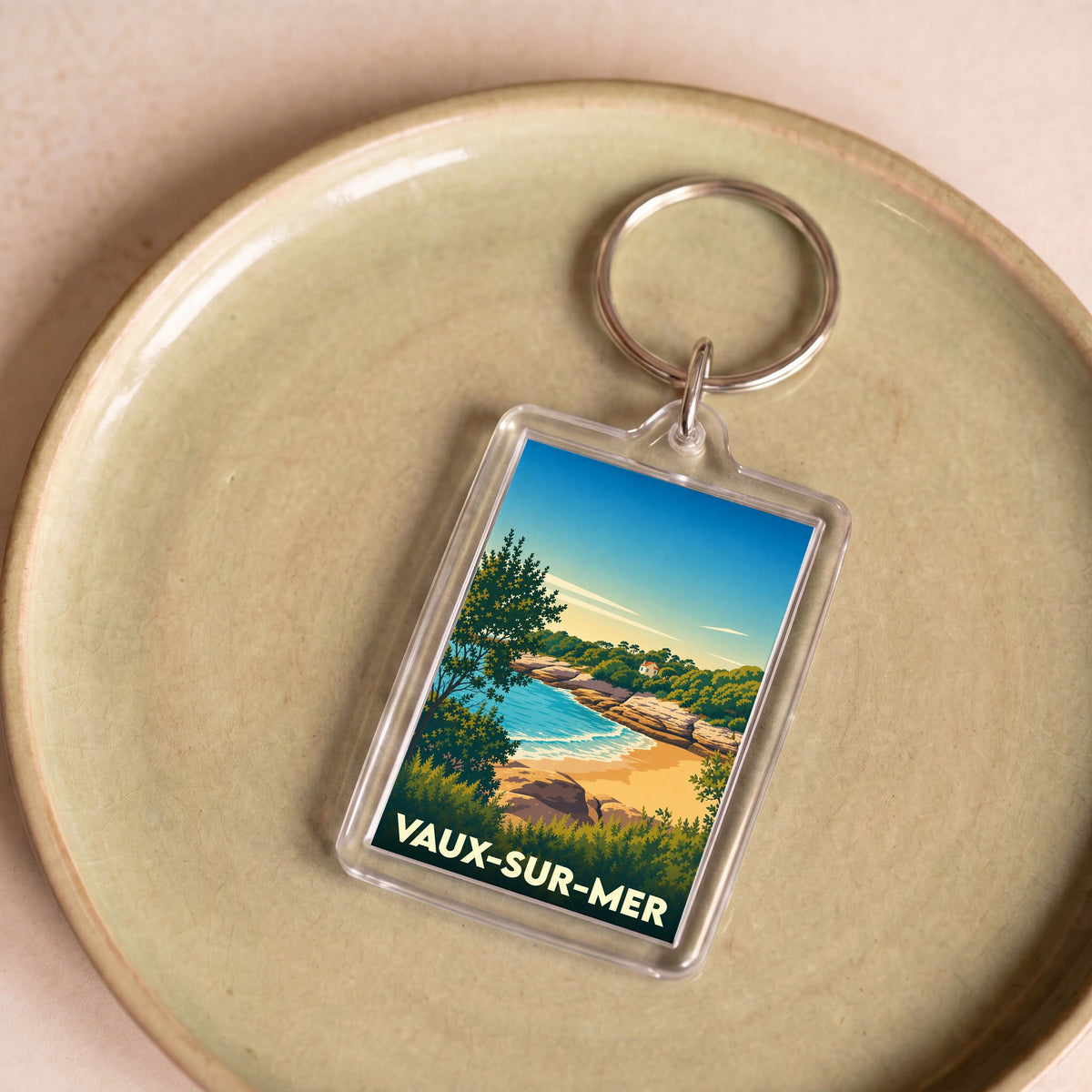 Porte-clés souvenir de la ville de Vaux-sur-Mer avec une illustration stylisée de sa côte.