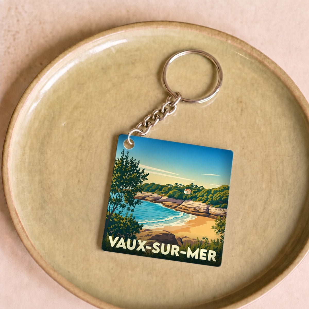 Porte-clés souvenir de la ville de Vaux-sur-Mer avec une illustration stylisée de sa côte.