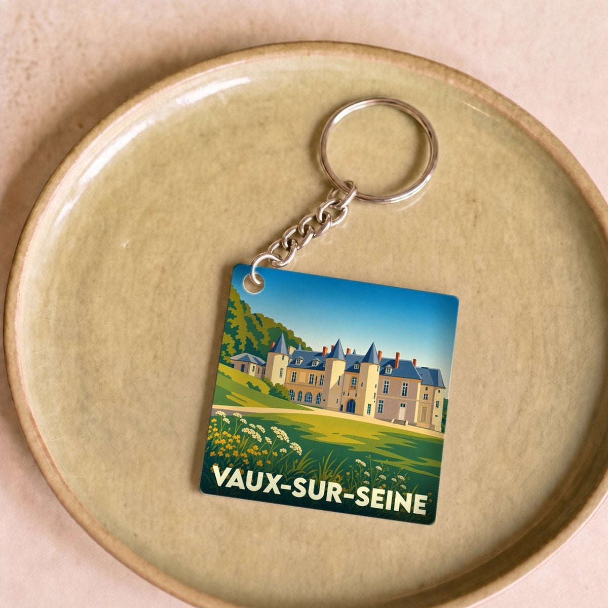 Porte-clés souvenir de la ville de Vaux-sur-Seine avec une illustration stylisée d'un château.