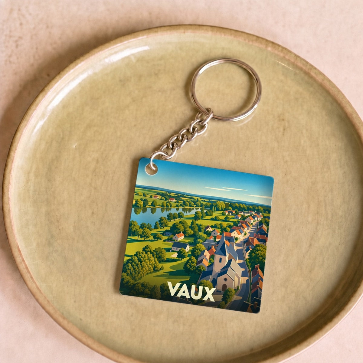 Porte-clés souvenir de la ville de Vaux avec une illustration stylisée.