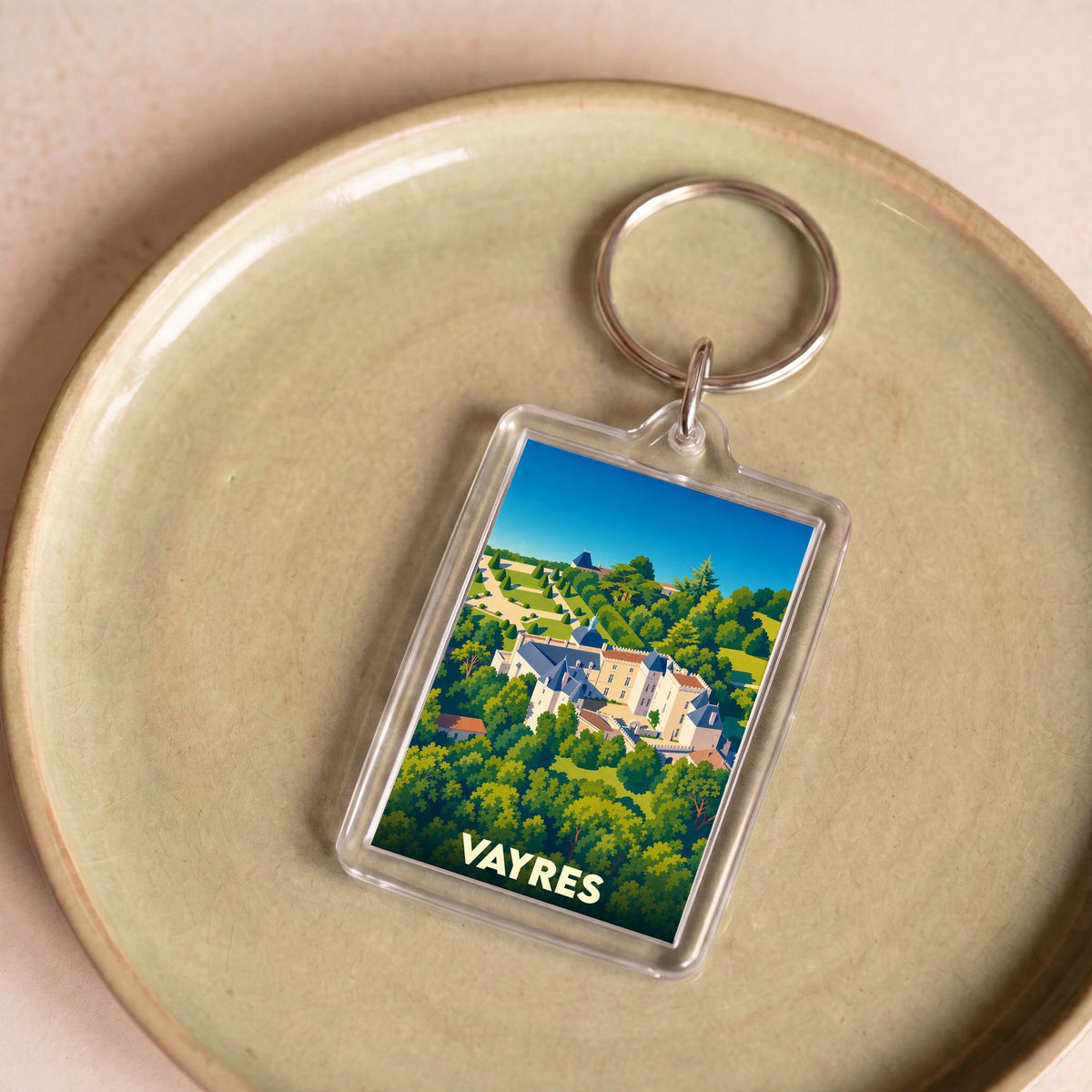 Porte-clés souvenir de la ville de Vayres avec une illustration stylisée de son château.