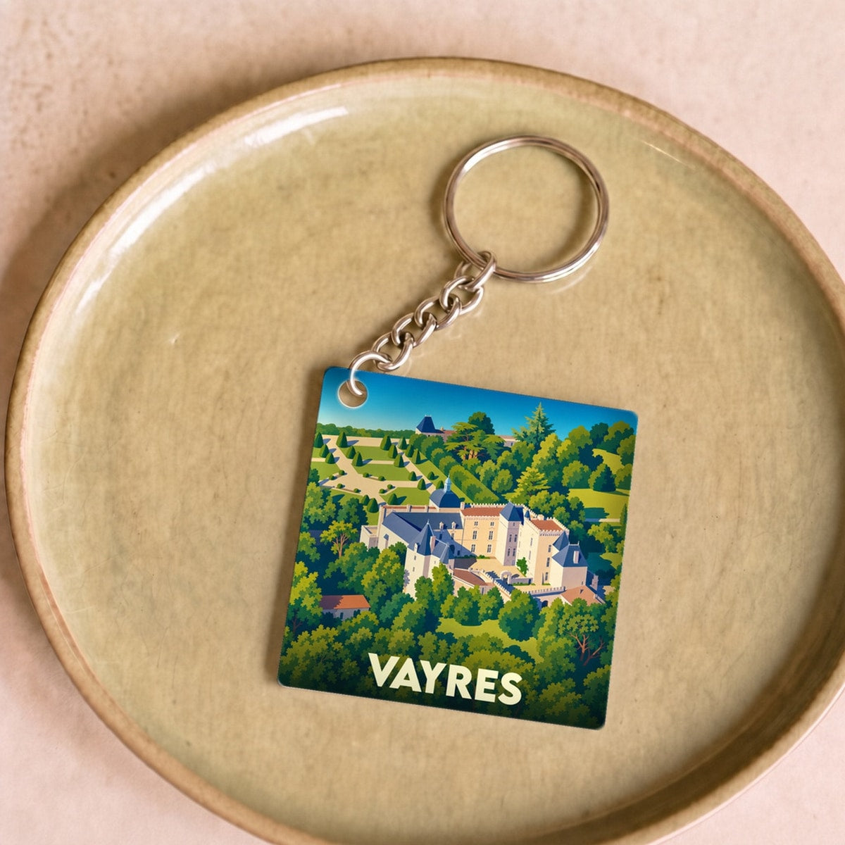 Porte-clés souvenir de la ville de Vayres avec une illustration stylisée de son château.