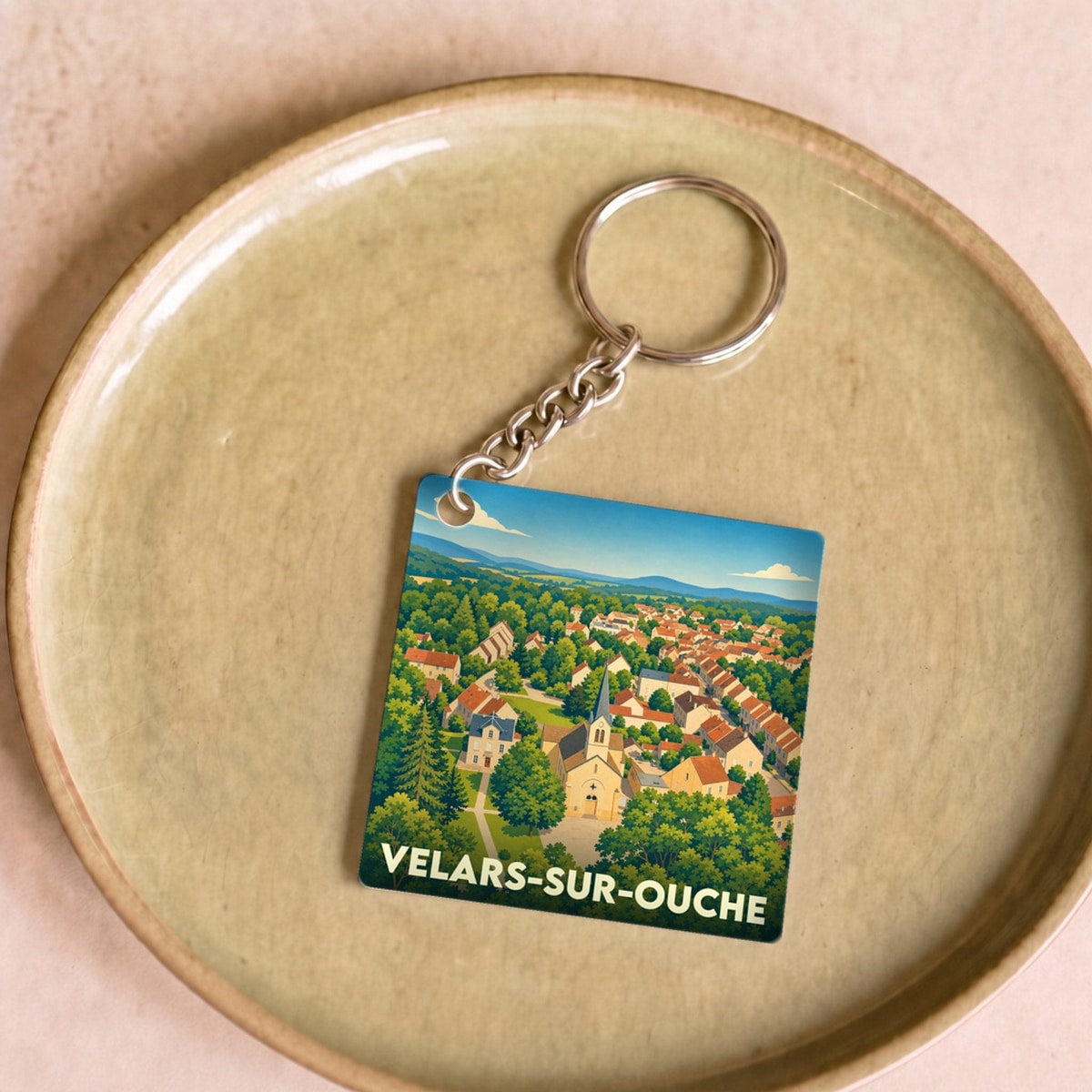 Porte-clés souvenir de la ville de Velars-sur-Ouche avec une illustration stylisée.