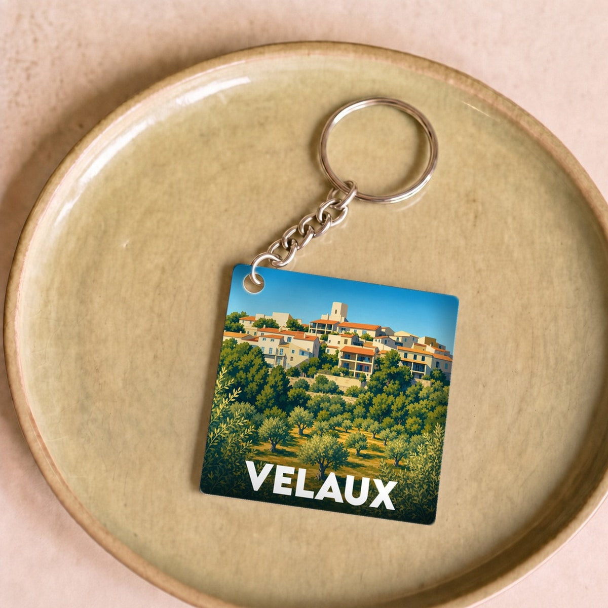 Porte-clés souvenir de la ville de Velaux avec une illustration stylisée.