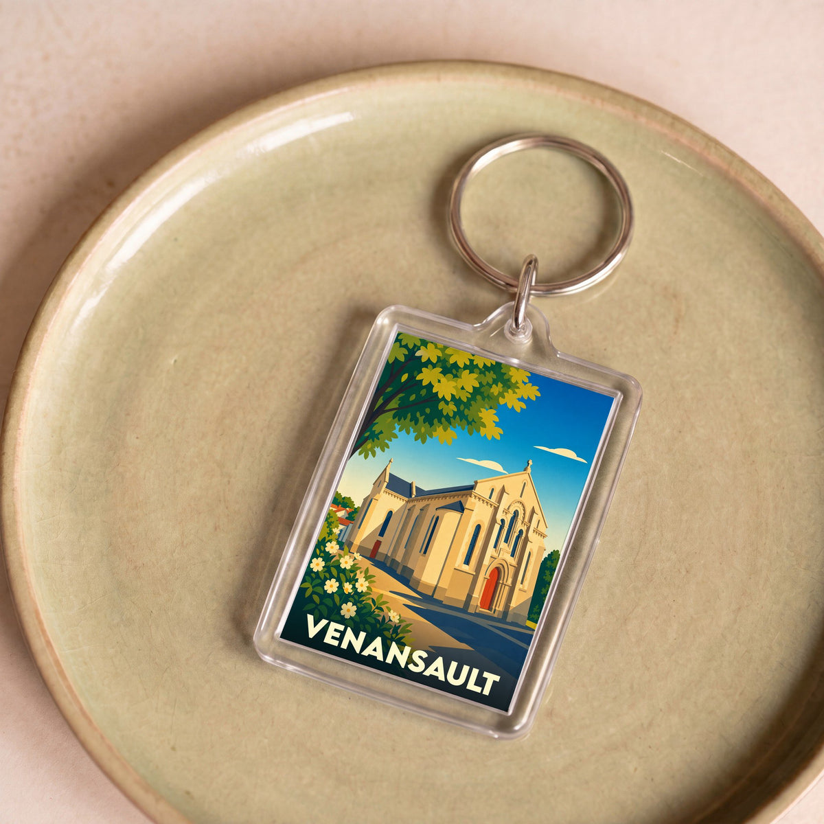 Porte-clés souvenir de la ville de Venansault avec une illustration stylisée de son église.