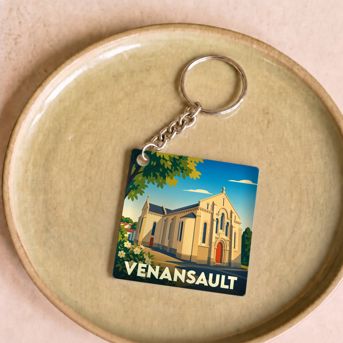 Porte-clés souvenir de la ville de Venansault avec une illustration stylisée de son église.