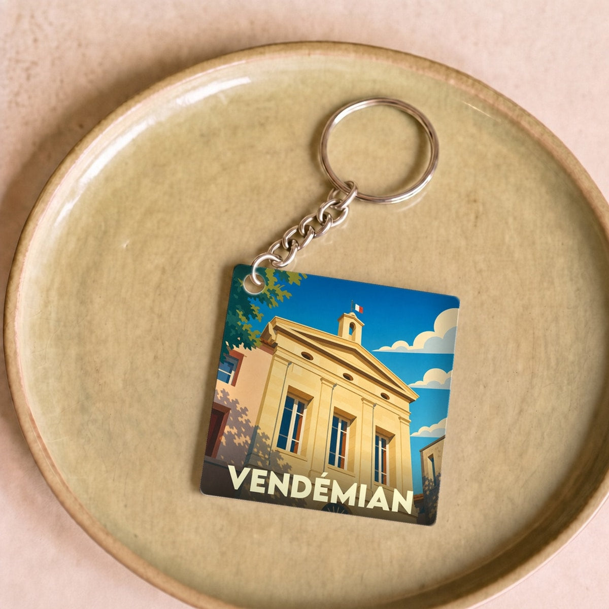 Porte-clés souvenir de la ville de Vendémian avec une illustration stylisée de sa mairie.