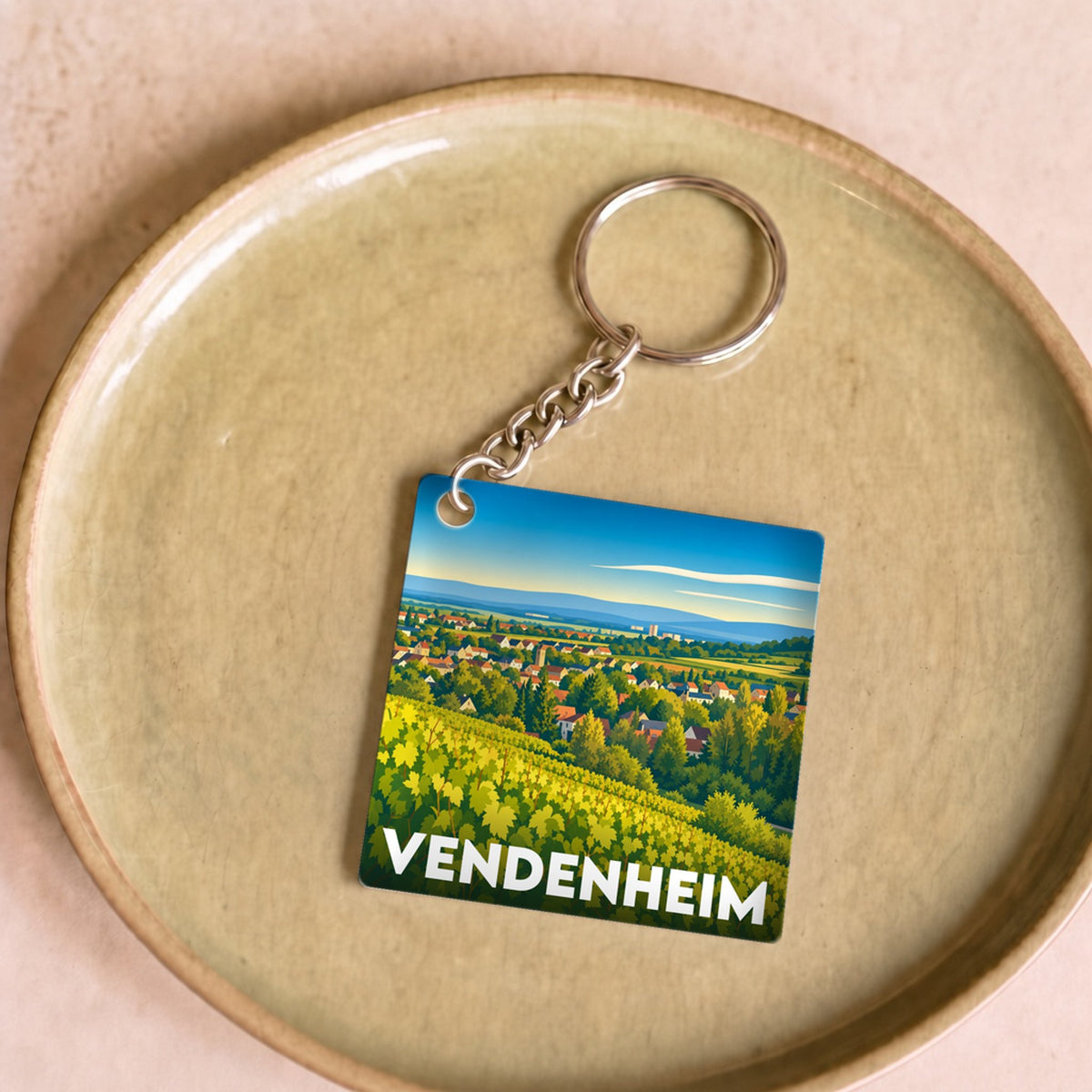Porte-clés souvenir de la ville de Vendenheim avec une illustration stylisée d'un paysage de vignobles.