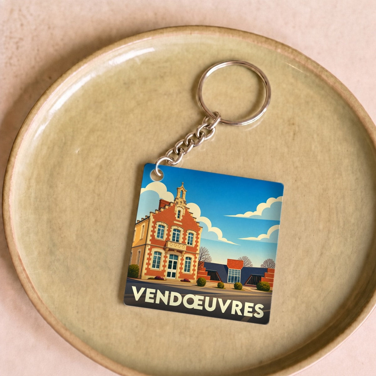 Porte-clés souvenir de la ville de Vendœuvres avec une illustration stylisée de sa mairie.
