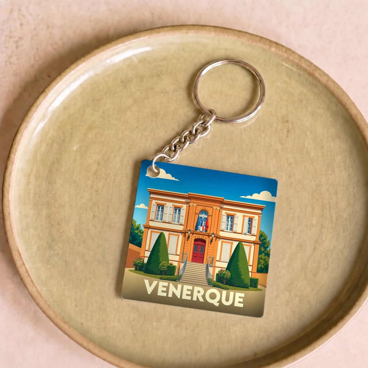 Porte-clés souvenir de la ville de Venerque avec une illustration stylisée de sa mairie.