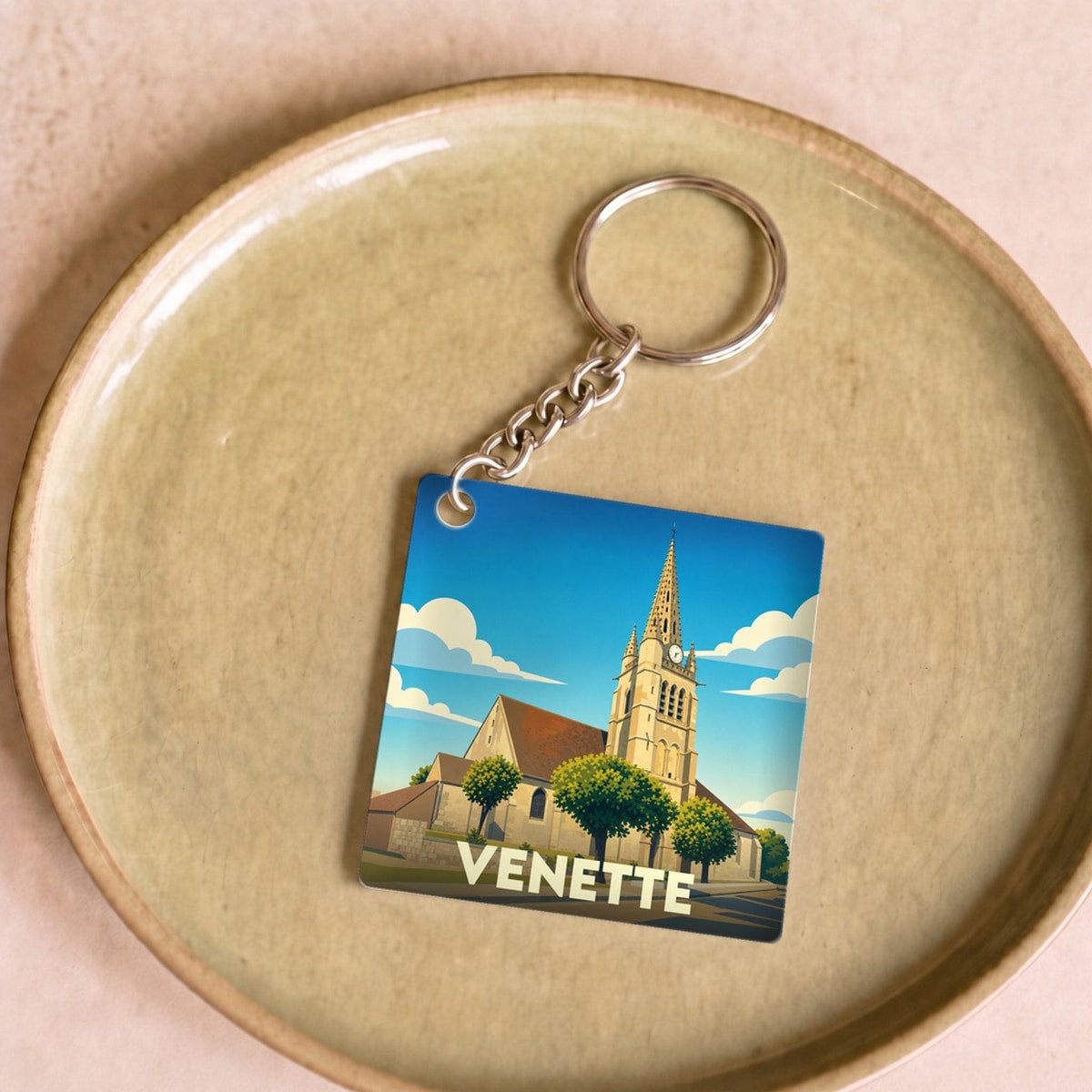 Porte-clés souvenir de la ville de Venette avec une illustration stylisée de son église.