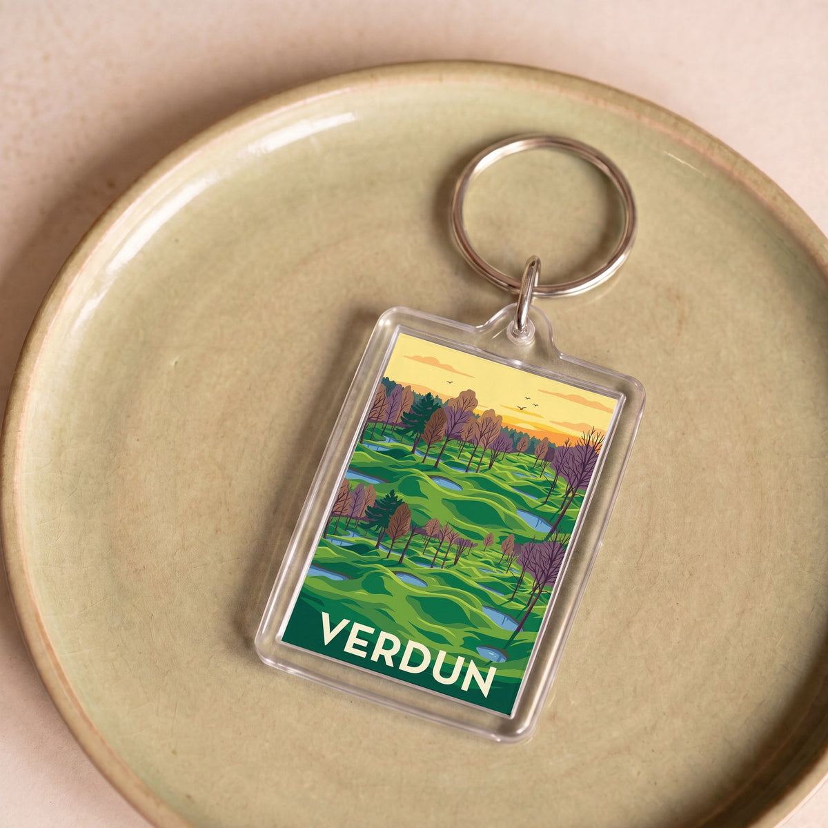 Porte-clés souvenir de la ville de Verdun avec une illustration stylisée de paysage.
