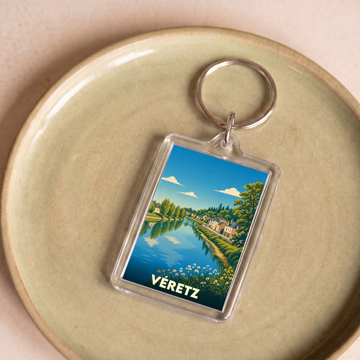 Porte-clés souvenir de la ville de Véretz avec une illustration stylisée d'un paysage fluvial.