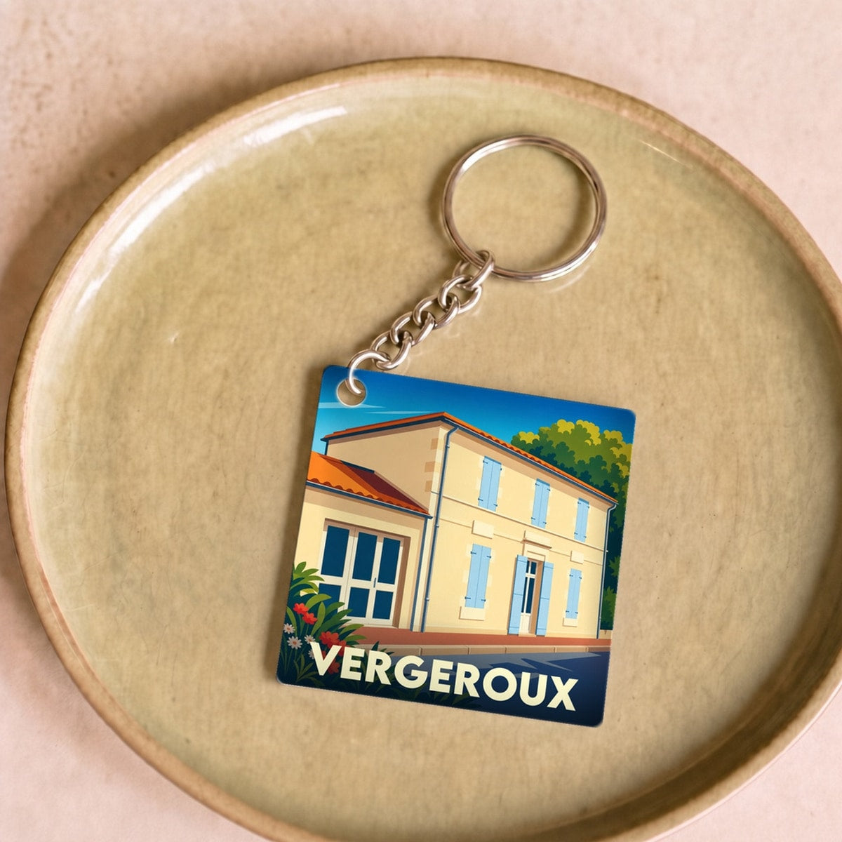 Porte-clés souvenir de la ville de Vergeroux avec une illustration stylisée d'une maison charentaise.