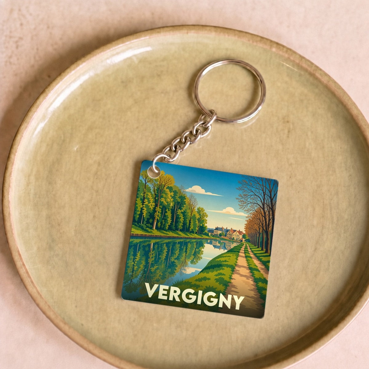 Porte-clés souvenir de la ville de Vergigny avec une illustration stylisée de son paysage.