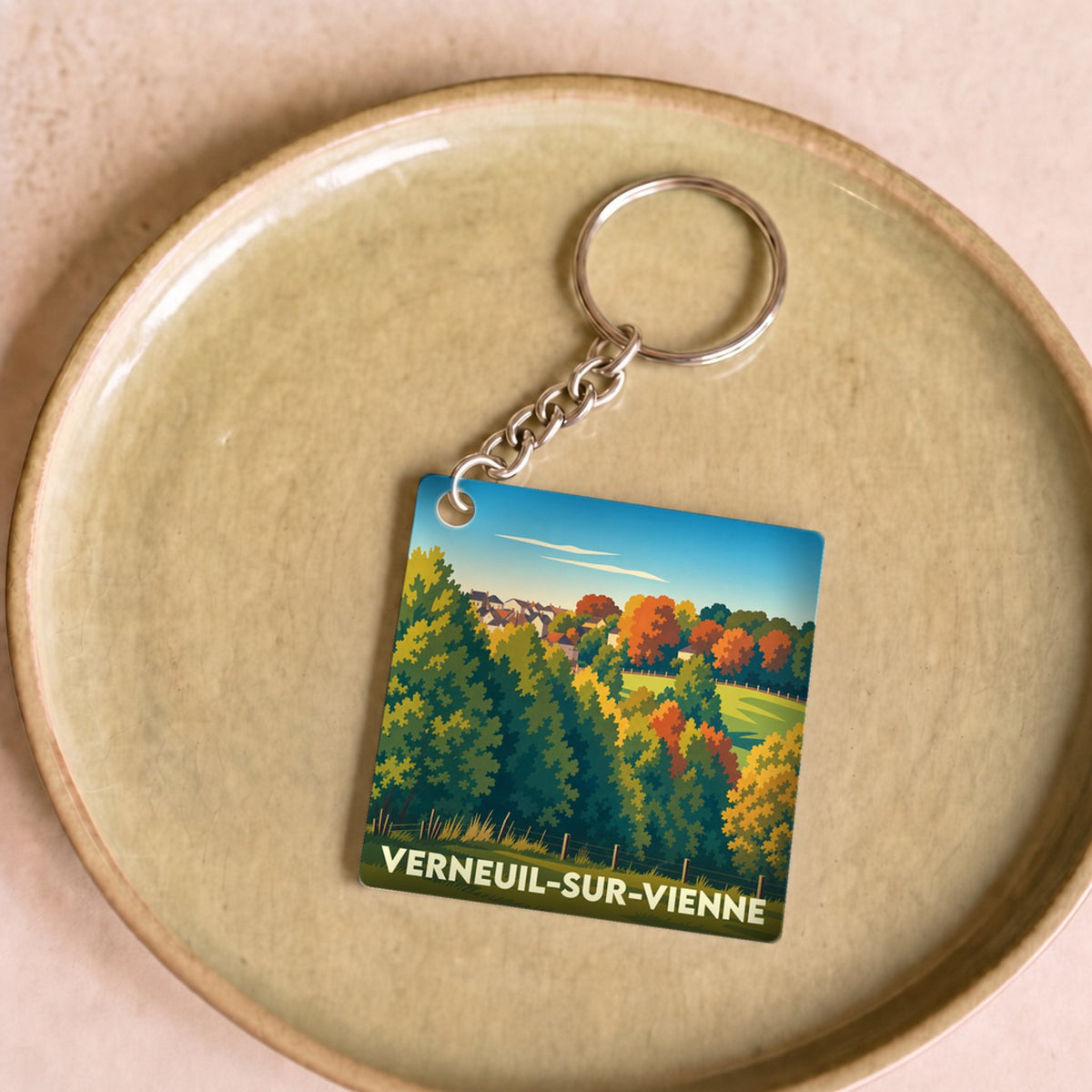 Porte-clés souvenir de la ville de Verneuil-sur-Vienne avec une illustration stylisée de paysage.